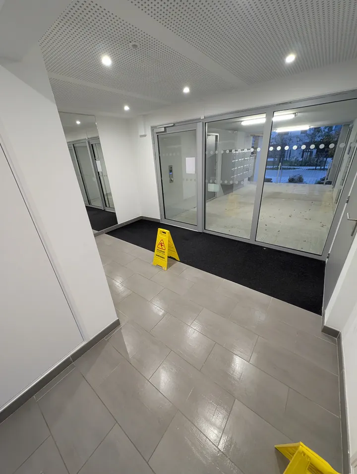 Hall d'entrée de copropriété nettoyé à Nantes, signalisation sol glissant en place
