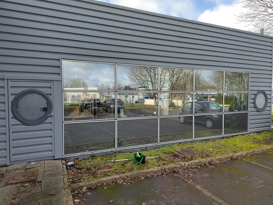 Nettoyage de la façade vitrée d'un local professionnel en Loire-Atlantique, matériel de vitrerie au pied des vitres